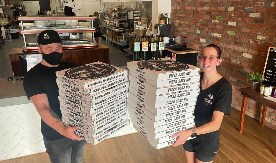 YUM: Bonnie and Clyde's Pizzeria staff members Tye Masiero and Ellie Exell were happy to see so many emergency workers enjoy some pizza. Picture: ALISON FOLETTA