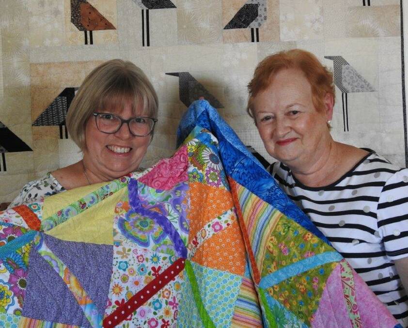 QUILTERS: Wimmera Hospice Care Auxiliary members Jan Ackland and Jenny Gilmartin show off Ms Ackland's stunning handmade quilts. Picture: CONTRIBUTED