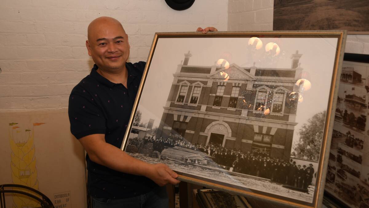 READY: Dimboola Imaginarium owner Chan Uoy stands with a 19th century picture of the National Australia Bank building. He said the picture inspired the idea to start a steampunk-themed festival. Picture: ALEX DALZIEL