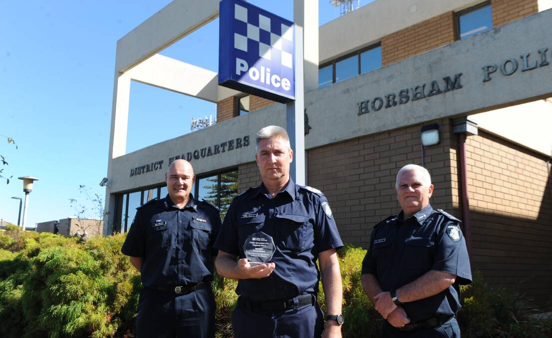 SERVICE: Horsham Superintendent Ian Milner (left), with Senior Sergeant Leigh Creasey and Acting Inspector Peter Robinson stand with the award out the front of Horsham Police Station. Picture: ALEX DALZIEL