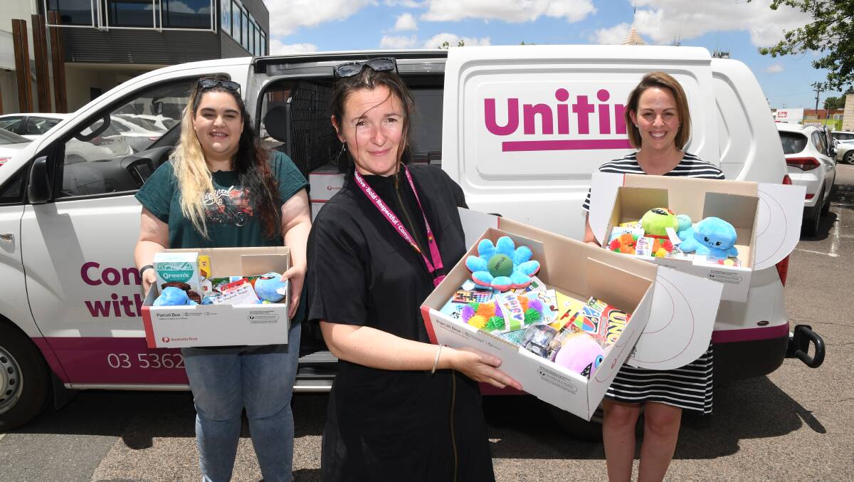 GOODIES: Uniting Wimmera's Ariana Vettos (left), Jules Del Real and Kate Waterworth hold the boredom buster boxes in front of Uniting's delivery van. Picture: ALEX DALZIEL