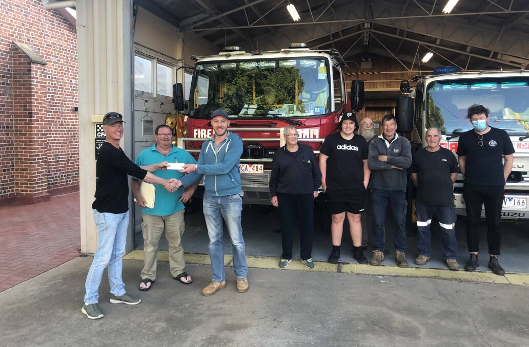 SUPPORT Ken Ough and Ceus Wolthius from the Dimboola Community Cropping Group presenting Dimboola captain Ash Wallace and brigade members with their generous donation towards the new fire station. Picture: CONTRIBUTED