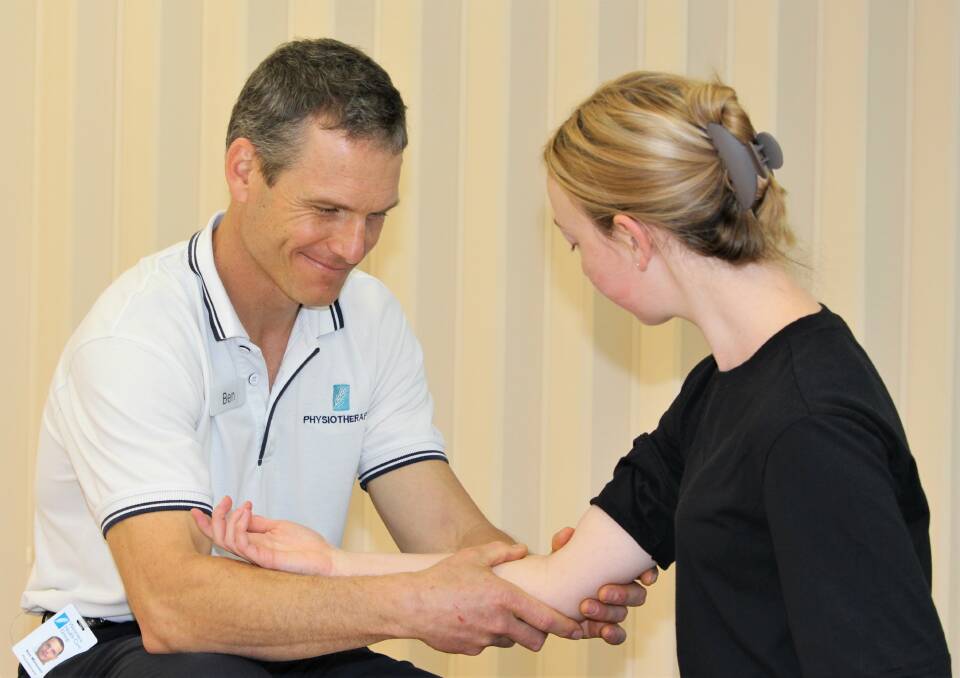 HELPING HAND: Chief physiotherapist Ben Wiessner helps a client with an arm injury. Picture: CONTRIBUTED