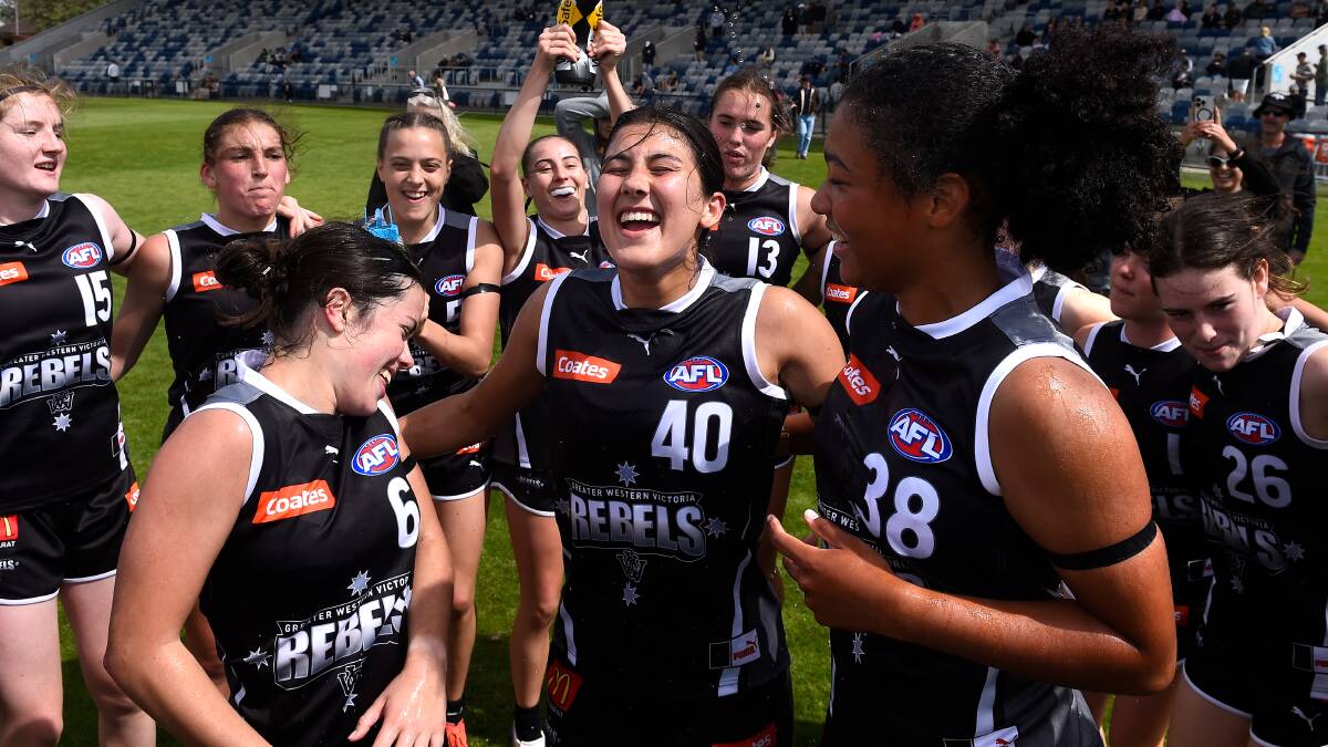 Debutantes Claire Lightfoot, Lara Antrobus and Remy Callender sing the team song after the Rebels win against Bendigo.