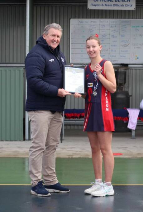 Laharum's Ava Bell has received her Blue Ribbon Spirit of Netball award from foundation member Les Power. Picture supplied