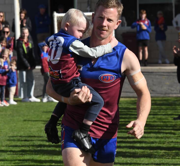 Brad Hartigan runs out onto Horsham City Oval with his son Freddie ahead of his 300th match against the Ararat Rats on Saturday, May 6. Picture by Lucas Holmes. 