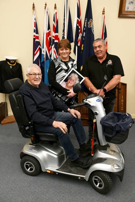 Diana Ferguson, holding a picture of her mother Theodora Barry, and Sebastopol RSL president Kevin Scott help offer Vietnam Tunnel Rat Bob Coleman a little more independence with the scooter. Picture by Lachlan Bence