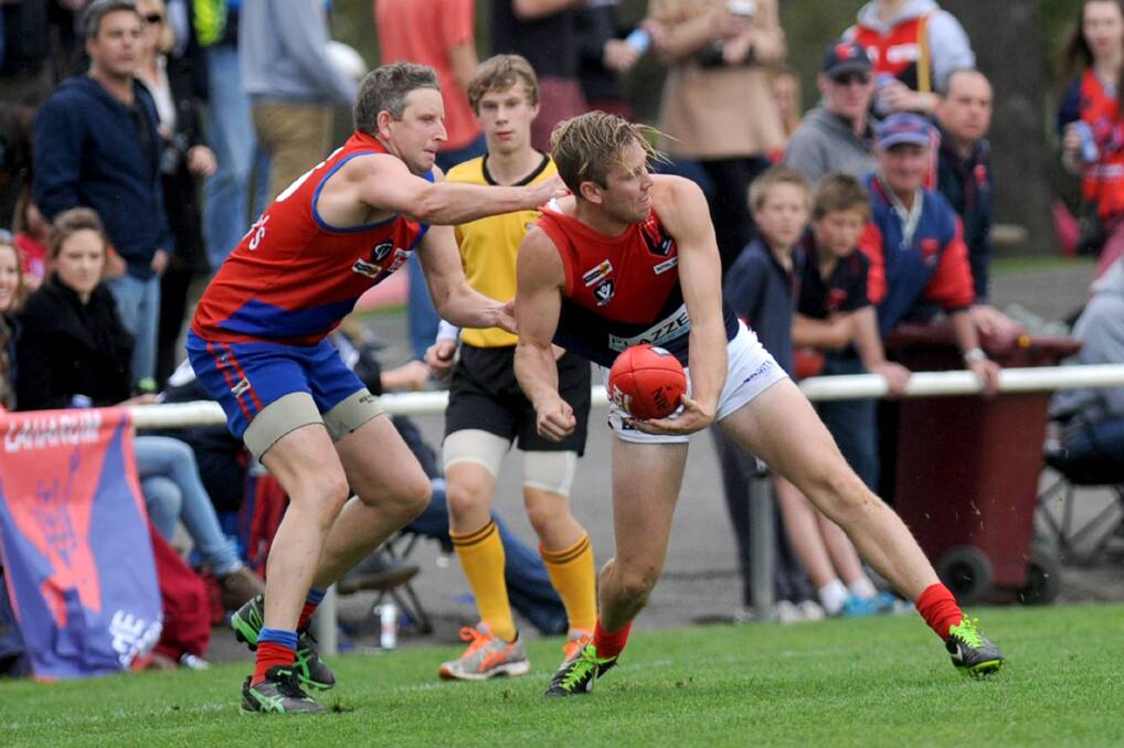 ULTIMATE SUCCESS: Alex Ellifson is tackled by Kalkee’s Adam Carter in last year’s grand final victory. Ellifson played only four senior games in 2013 but collected a premiership medal. 