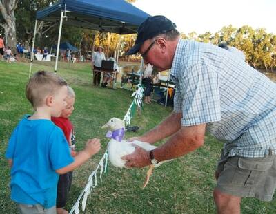 PETTING TIME: Nhill Duck and Jazz organiser Ian Marra holds a duck for children to pat prior to the Nhill Duck and Jazz duck race. Picture: CONTRIBUTED